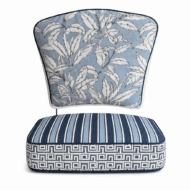 Blue and white outdoor canvas chair cushion set with botanical leaf back cushion and striped geometric seat cushion