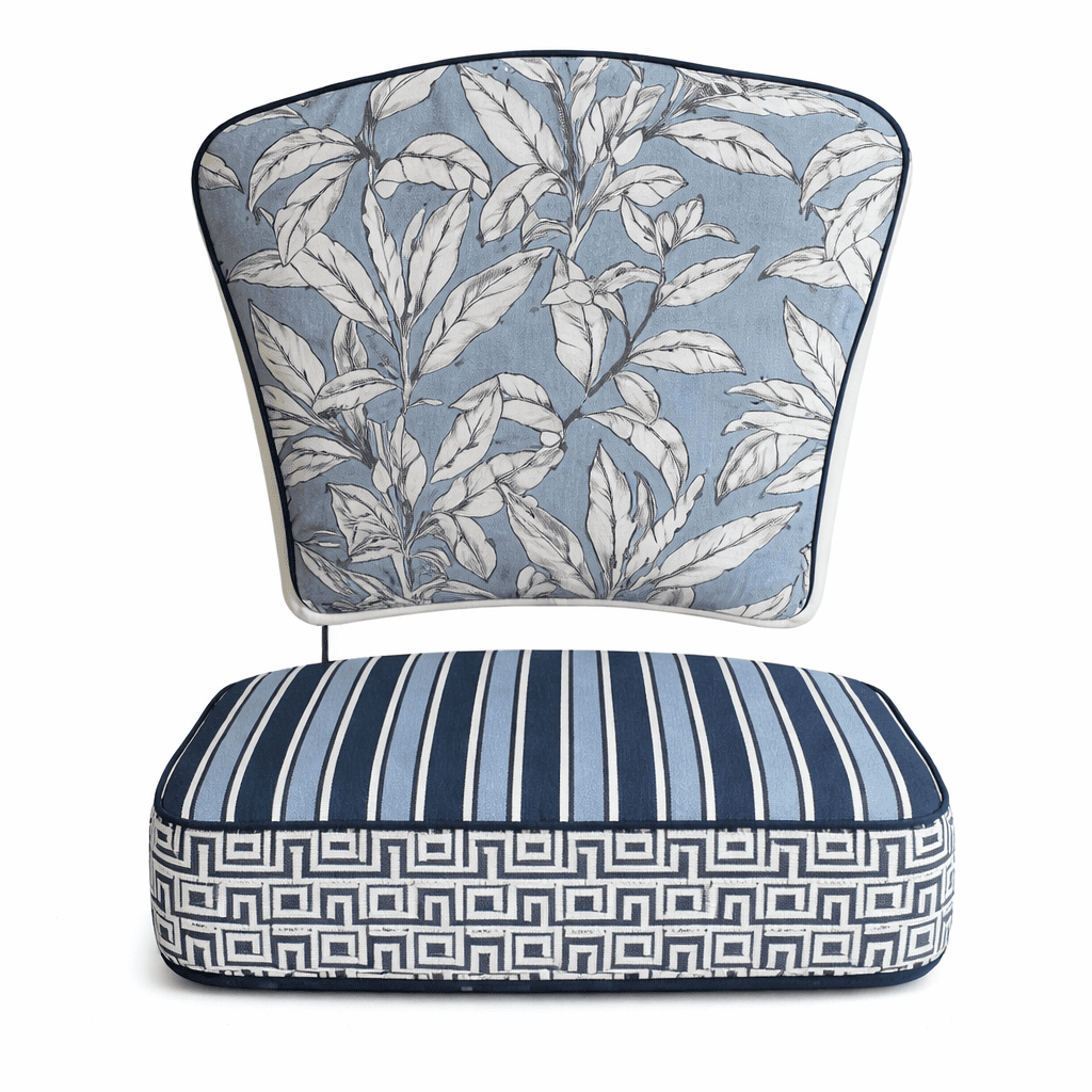 Blue and white outdoor canvas chair cushion set with botanical leaf back cushion and striped geometric seat cushion
