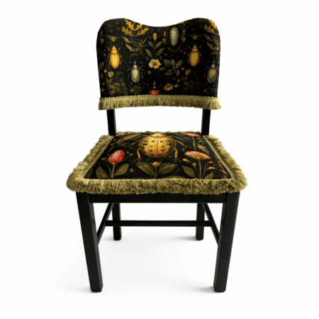 Black wood chair with beetle and botanical print upholstery and fringed trim.