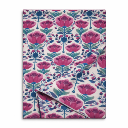 Ivory table runner with bold pink floral print and teal botanical stems, folded to show fabric texture
