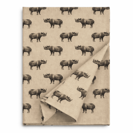 Neutral linen table runner with repeated illustrated rhino print, folded to show fabric texture