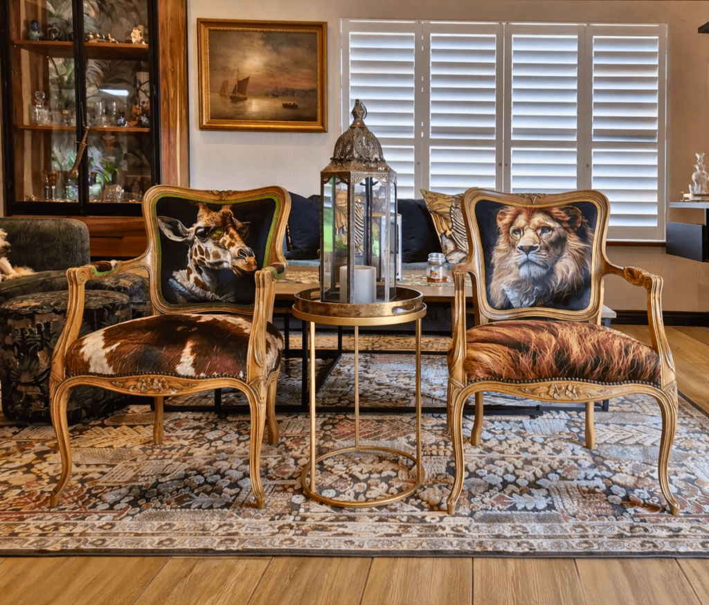 Carved wooden armchairs with giraffe and lion print backs and animal-hide style seats.