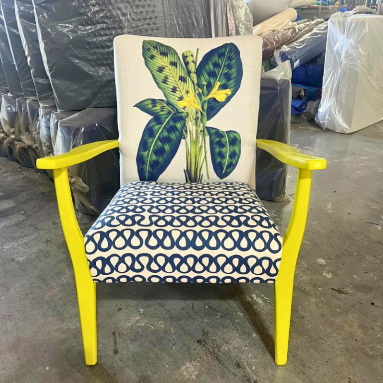 Yellow wood chair with botanical leaf print back and navy swirl seat.
